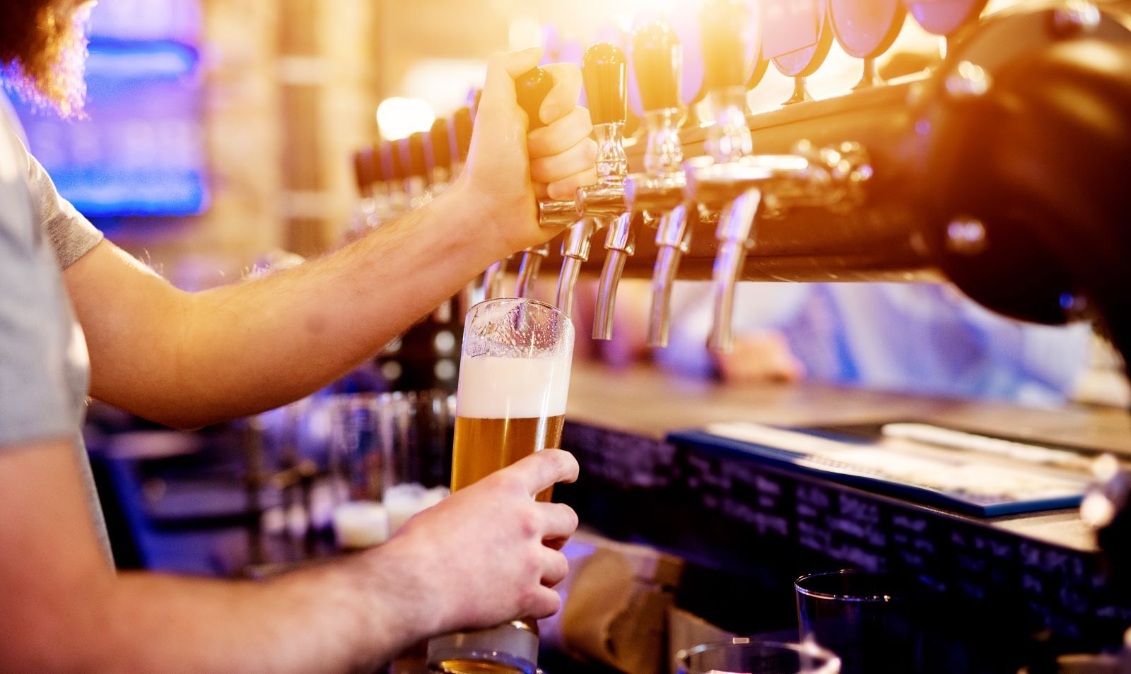 person pouring a beer at a brewery