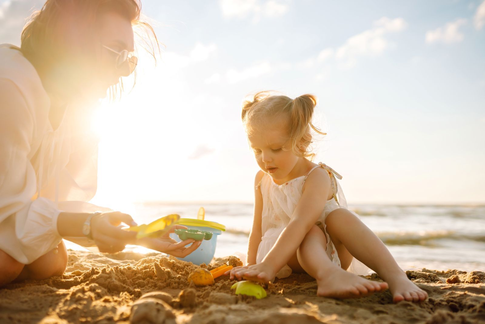 young girl playing in sand at the beach